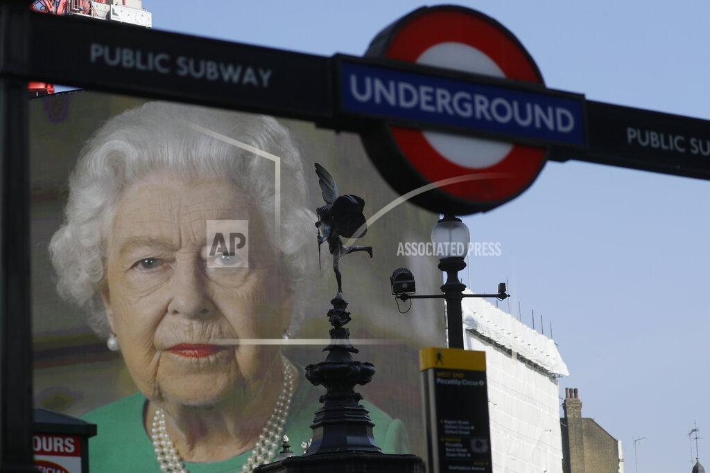 Kirsty Wigglesworth FILE - In this Thursday, April 9, 2020 file photo an image of Britain's Queen Elizabeth II and quotes from her historic television broadcast commenting on the coronavirus pandemic are displayed on a big screen behind the Eros statue and a London underground train station entrance sign at Piccadilly Circus in London. (AP Photo/Kirsty Wigglesworth, File)