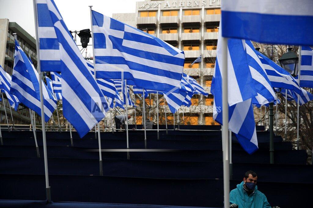 Thanassis Stavrakis Workers place Greek flags at a tribune, ahead of a military parade, in Athens, Tuesday, March 23, 2021. The military parade on March 25, marking 200-years since the war that resulted in Greece's independence from the Ottoman Empire and rebirth as a nation, will be held without spectators due to the coronavirus. (AP Photo/Thanassis Stavrakis)
