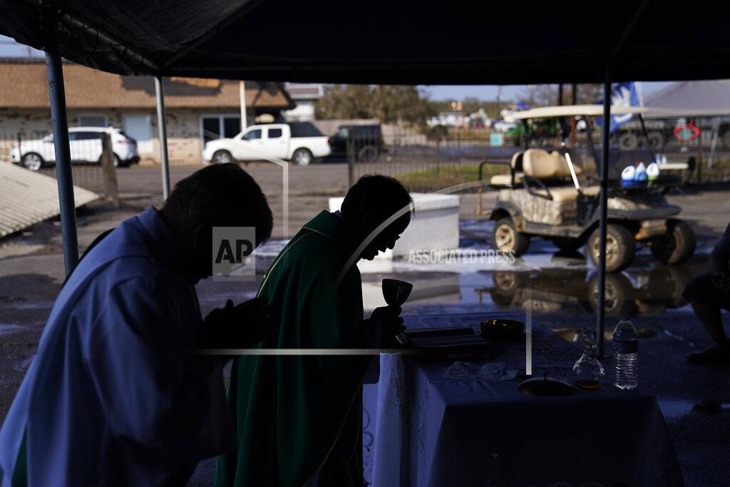 John Locher The Rev. Luke Nguyen, right, celebrates Mass in a flood damaged parking lot in the aftermath of Hurricane Ida, Sunday, Sept. 5, 2021, in Jean Lafitte, La. The service was held in a parking lot after St. Anthony Catholic Church was flooded in the hurricane. (AP Photo/John Locher)