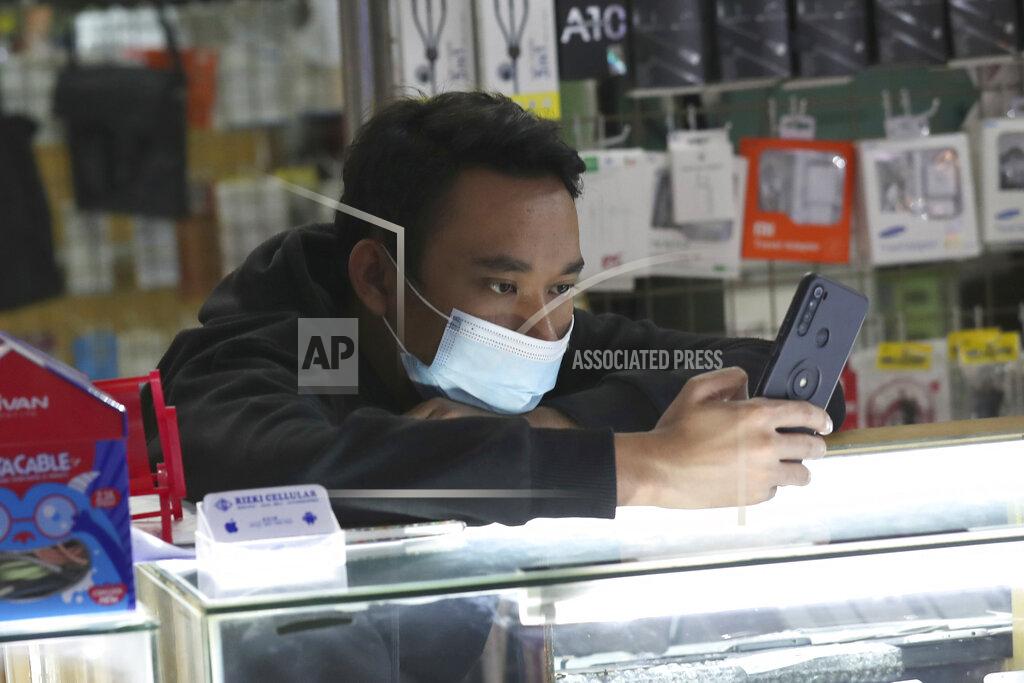 Tatan Syuflana A smartphone seller wearing a face mask as a precaution against coronavirus outbreak waits for customers at a stall of a shopping mall in Jakarta, Indonesia, Monday, Jan. 4, 2021. Indonesia has reported more cases of the virus than any other countries in Southeast Asia and second in Asia only to India. (AP Photo/Tatan Syuflana)