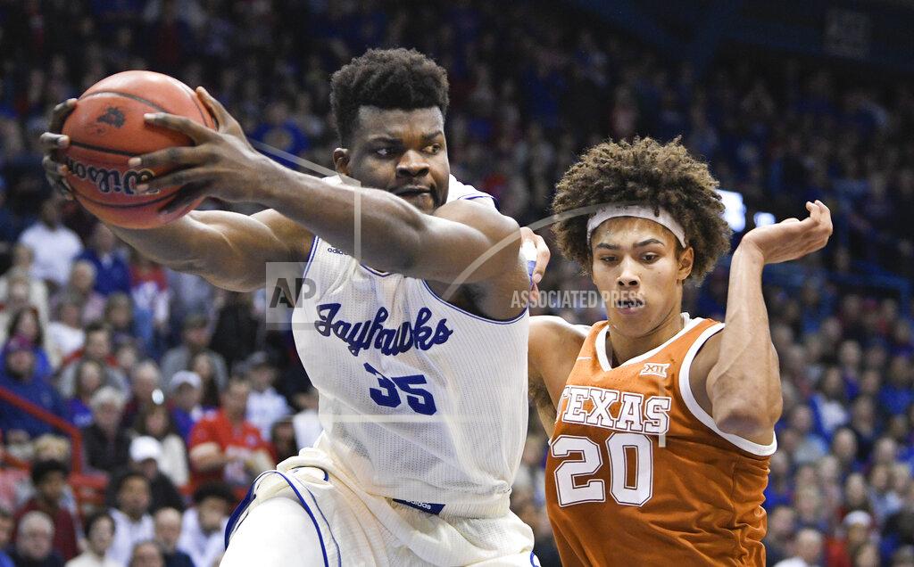 Reed Hoffmann Kansas center Udoka Azubuike (35) pulls down a rebound in front of Texas forward Jericho Sims (20) during the second half of an NCAA college basketball game in Lawrence, Kan., Monday, Feb. 3, 2020. (AP Photo/Reed Hoffmann