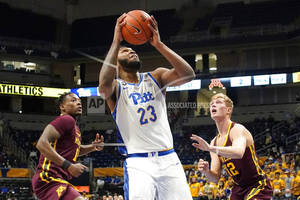 Keith Srakocic Pittsburgh's John Hugley (23) shoots between Minnesota's Charlie Daniels, left, and Luke Loewe (12) during the first half of an NCAA college basketball game Tuesday, Nov. 30, 2021, in Pittsburgh. (AP Photo/Keith Srakocic)