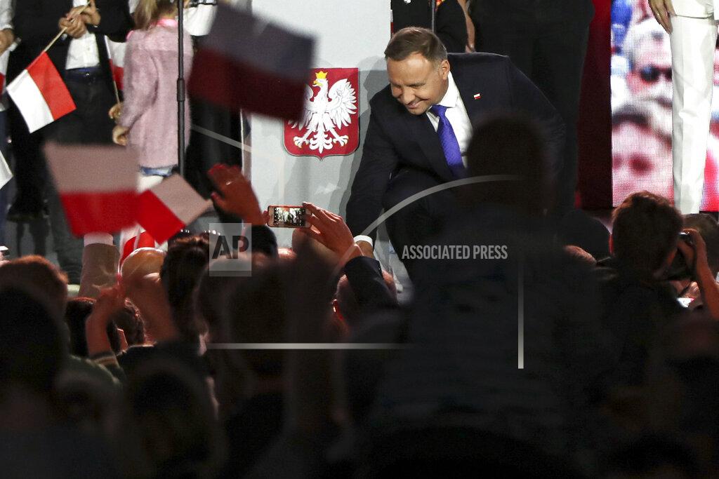 Czarek Sokolowski Incumbent President Andrzej Duda shakes hands with supporters in Pultusk, Poland, Sunday, July 12, 2020. An exit poll in Poland's presidential runoff election shows a tight race that is too close to call between the conservative incumbent, Andrzej Duda, and the liberal Warsaw mayor, Rafal Trzaskowski.(AP Photo/Czarek Sokolowski)