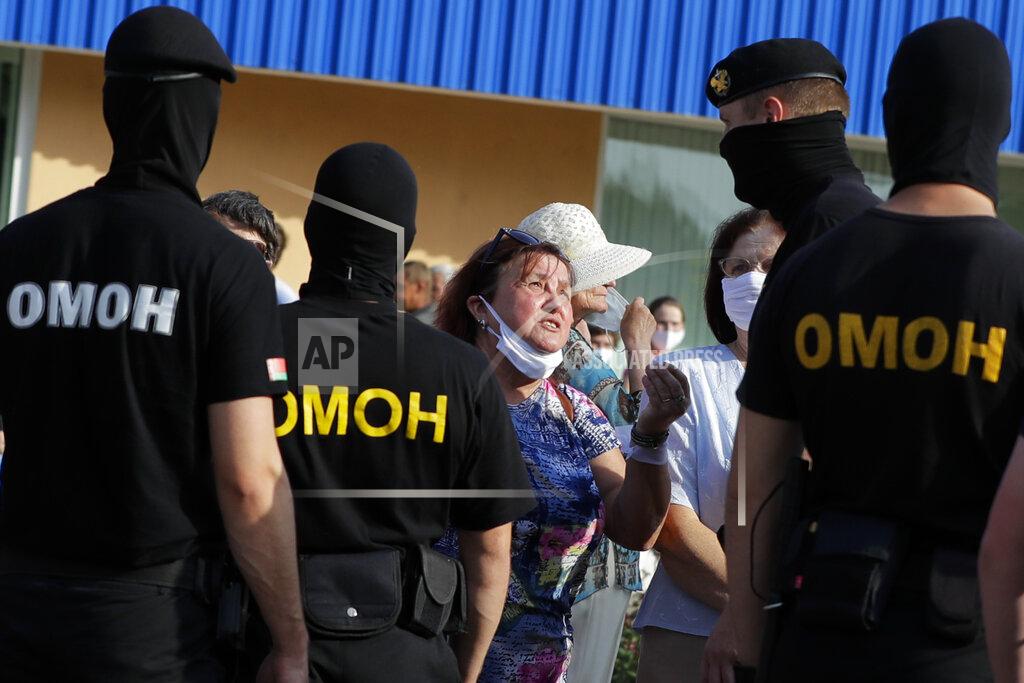 A woman argues with police as they block protesters , to prevent a rally in support opposition candidate Sviatlana Tsikhanouskaya ahead of Sunday's election in Slutsk, Belarus, Tuesday, Aug. 4, 2020. Belarusian police on Tuesday abruptly banned Tsikhanouskaya's previously approved rally in the city of Slutsk, about 100 kilometers (about 60 miles) south of Minsk, under the pretext of road repairs. Officers dispersed several hundred people who had gathered for the rally and detained at least 20 of them, according to Belarusian human rights organization Viasna. (AP Photo/Sergei Grits)