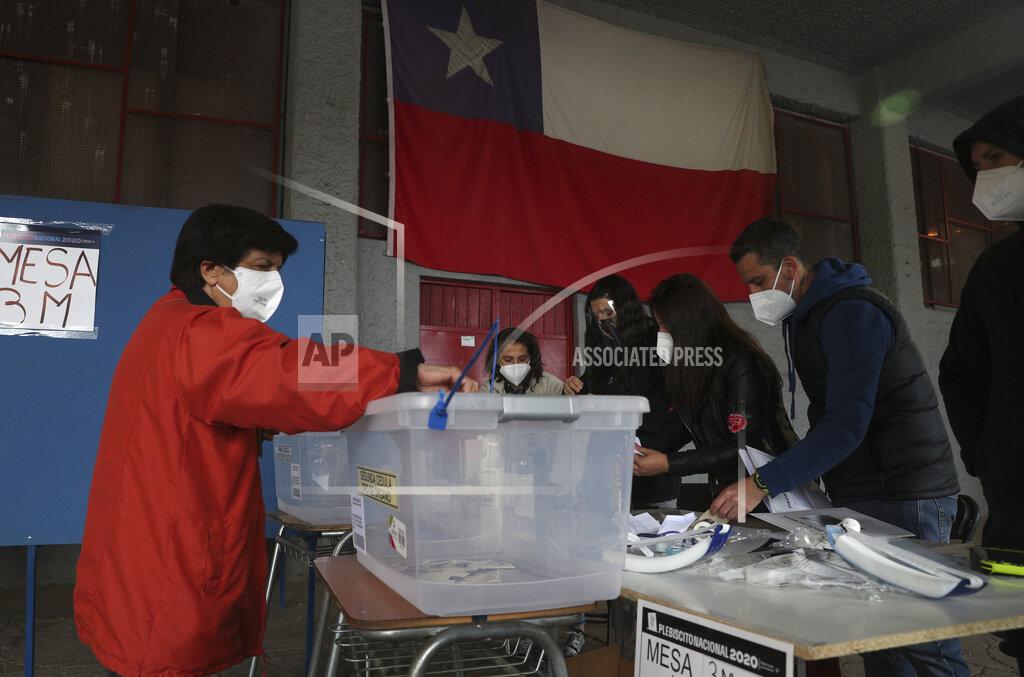 Esteban Felix A woman votes at a polling station in Santiago, Chile, Sunday, Oct. 25, 2020. Amid a year of contagion and turmoil, Chileans vote Sunday on whether to draft a new constitution for their nation to replace guiding principles imposed four decades ago under a military dictatorship.(AP Photo/Esteban Felix)