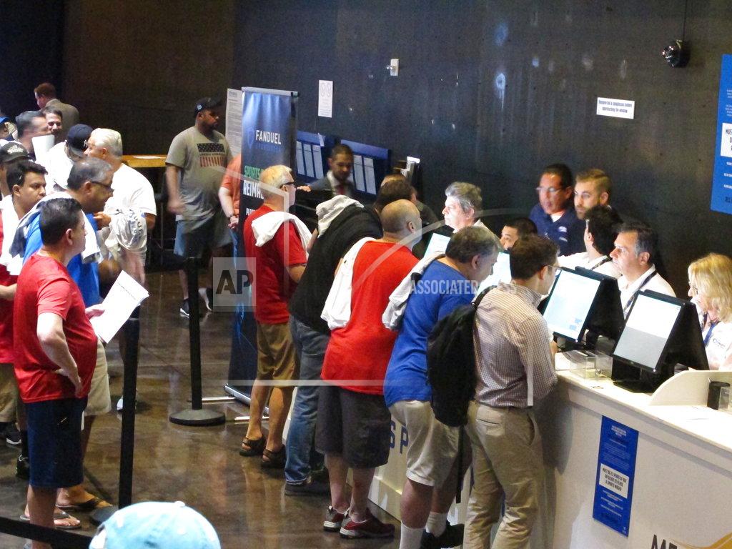 Wayne Parry This July 14, 2018 file photo shows gamblers placing bets on sports events at the FanDuel sports book at the Meadowlands Racetrack in East Rutherford, N.J., on the day it opened. On Nov. 30, 2018, FanDuel paid out bets on Alabama to win the national college football championship a month before the game is played. (AP Photo/Wayne Parry, File)