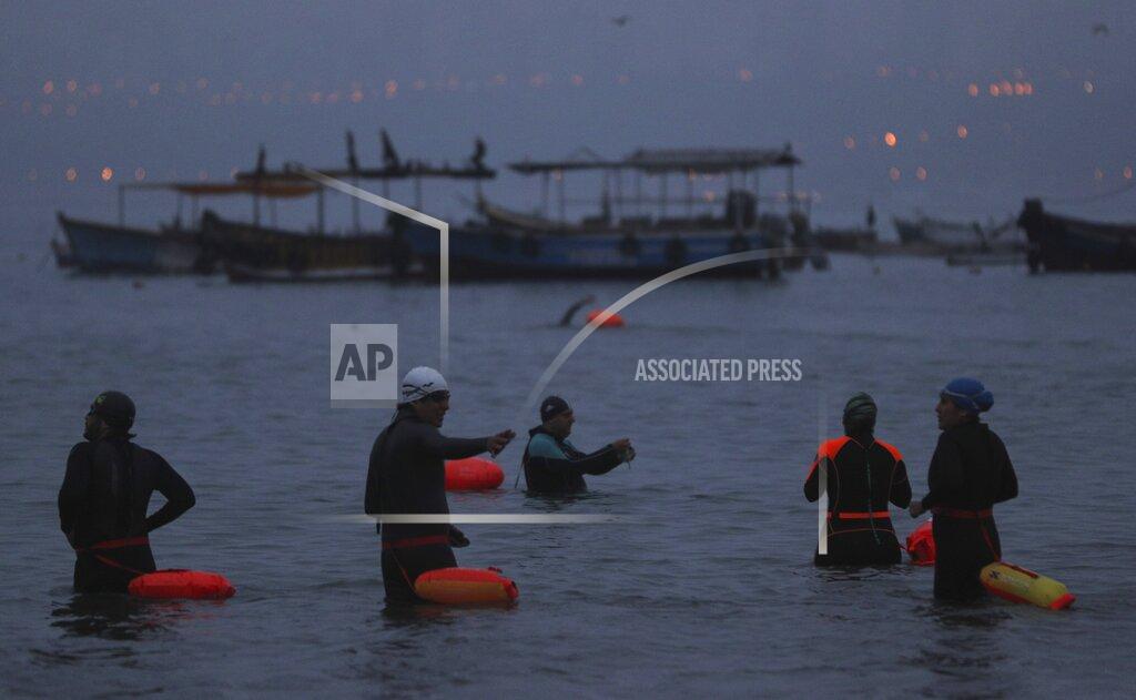 Martin Mejia People get ready to swim off Pescadores beach where open water swimming is booming while pools are closed due to the COVID-19 pandemic in Lima, Peru, at sunrise Tuesday, April 27, 2021. One of the few sporting disciplines that have been maintained during the coronavirus pandemic is swimming, which due to the closure of the swimming pools, has moved to the open sea. (AP Photo/Martin Mejia)