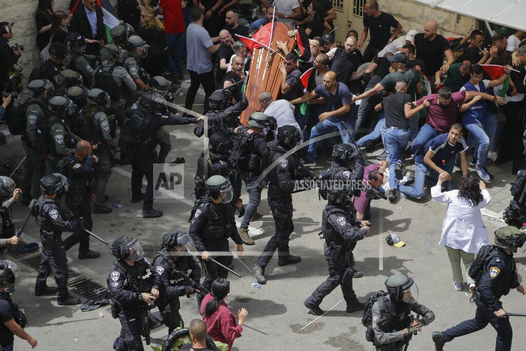 Maya Levin Israeli police confront with mourners as they carry the casket of slain Al Jazeera veteran journalist Shireen Abu Akleh during her funeral in east Jerusalem, Friday, May 13, 2022. Abu Akleh, a Palestinian-American reporter who covered the Mideast conflict for more than 25 years, was shot dead Wednesday during an Israeli military raid in the West Bank town of Jenin. (AP Photo/Maya Levin)
