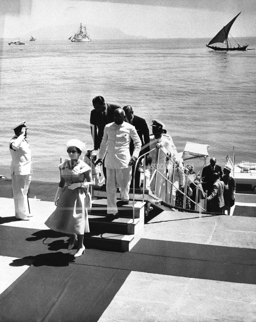 Uncredited FILE - In this file photo dated Feb. 26, 1961, Britain's Queen Elizabeth II steps ashore at Bombay, India, for a visit to the atomic energy plant at the "Gateway to India," which King George V called "the jewel of the British crown" during his 1911 visit. Prince Philip who is accompanying the Queen on the state tour, can be seen nearing top of the Gangplank hat in hand. Prince Philip who died Friday April 9, 2021, aged 99, lived through a tumultuous century of war and upheavals, but he helped forge a period of stability for the British monarchy under his wife, Queen Elizabeth II. Philip helped create the Commonwealth of nations, with the queen at its head, in an attempt to bind Britain and its former colonies together on a more equal footing. (AP Photo, FILE)