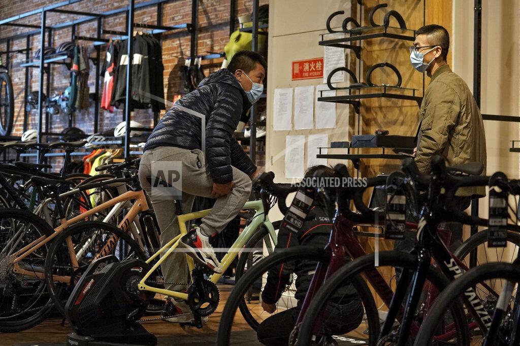 Customers wearing face masks to help curb the spread of the coronavirus chat each other as they try out the American bicycle brand at a retail shop in Beijing Tuesday, March 2, 2021. Chinese leaders are shifting focus from the coronavirus back to long-term goals of making China a technology leader at this year's highest-profile political event, the meeting of its ceremonial legislature, amid tension with Washington and Europe over trade, Hong Kong and human rights. (AP Photo/Andy Wong)