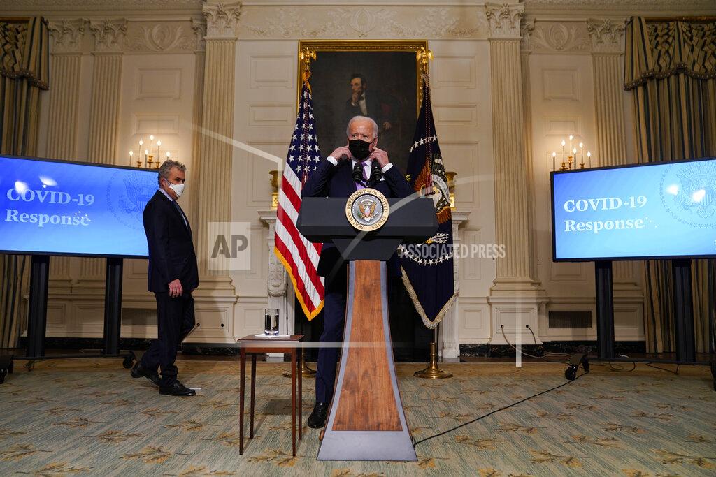 Evan Vucci President Joe Biden removes his face mask before delivering remarks on COVID-19, in the State Dining Room of the White House, Tuesday, Jan. 26, 2021, in Washington. (AP Photo/Evan Vucci)
