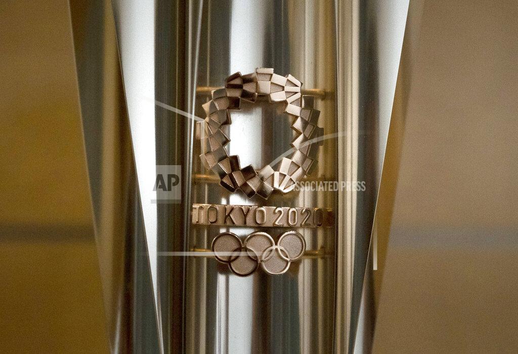 An Olympic torch for the Tokyo 2020 Olympics is on display in Tokyo, Tuesday, March 24, 2020. Japan has announced Thursday, Jan. 7, 2021, that it is halting a public display of the Tokyo Olympic and Paralympic torches as virus case jump in the country and Prime Minister Yoshihide Suga orders a state of emergency for Tokyo and the surrounding areas until next month. (AP Photo/Jae C. Hong, File)