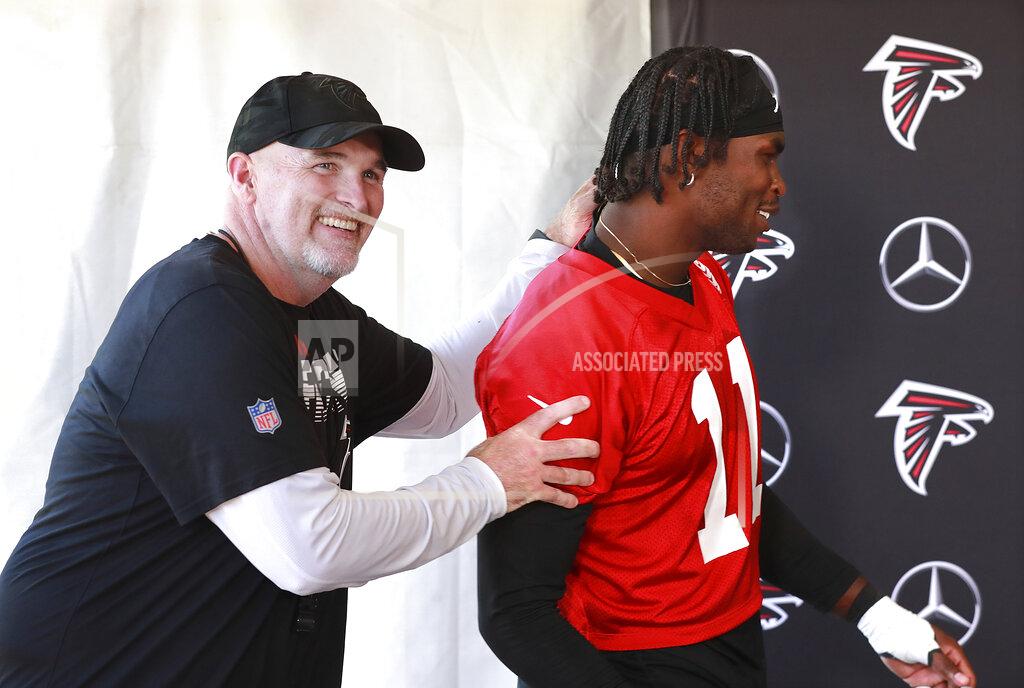 Atlanta Falcons head coach Dan Quinn, left, clowns around with wide receiver Julio Jones as he arrives for his press conference at NFL football training camp in Flowery Branch, Ga., Wednesday, July 24, 2019. (Curtis Compton/Atlanta Journal-Constitution via AP)