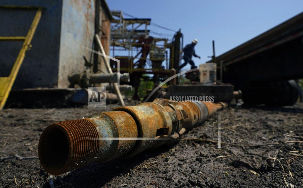 Eric Gay An oil well worker moves equipment at a site on the Rooke family ranch where an orphaned well was plugged, Tuesday, May 18, 2021, near Refugio, Texas. There are 3.2 million abandoned oil and gas wells in the U.S., according to the Environmental Protection Agency. About a third were plugged with cement, which is considered the proper way to prevent harmful chemical leaks. But most, about 2.1 million by the EPA's count, haven't been plugged at all. (AP Photo/Eric Gay)