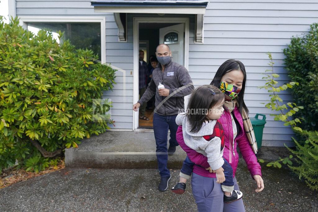 Ted S. Warren Thuy Do, right, walks with her husband, Jesse Robbins, left, and their son, Fredrick, Monday, Sept. 20, 2021. Do was nine years old when her family arrived in the United States from Vietnam in the 1980s, and that memory led Do and Robbins to reach out to assist Afghans fleeing their country. (AP Photo/Ted S. Warren)