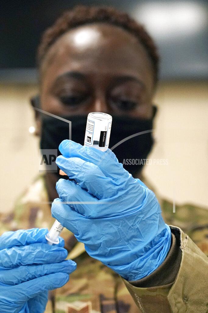 Rogelio V. Solis Mississippi Air Guard Tech. Sgt. Exstrella Smith withdraws a dose of the Moderna COVID-19 vaccine for injection into the arm of a Mississippi Air or Army National Guard service member who serves as a first responder, Wednesday, Dec. 23, 2020, in Flowood, Miss. One hundred doses of the vaccine were administered to both Mississippi Air and Army National Guard service members who currently assist with the administering of the COVID-19 test at Mississippi Department of Health drive through community testing sites across the state. (AP Photo/Rogelio V. Solis)
