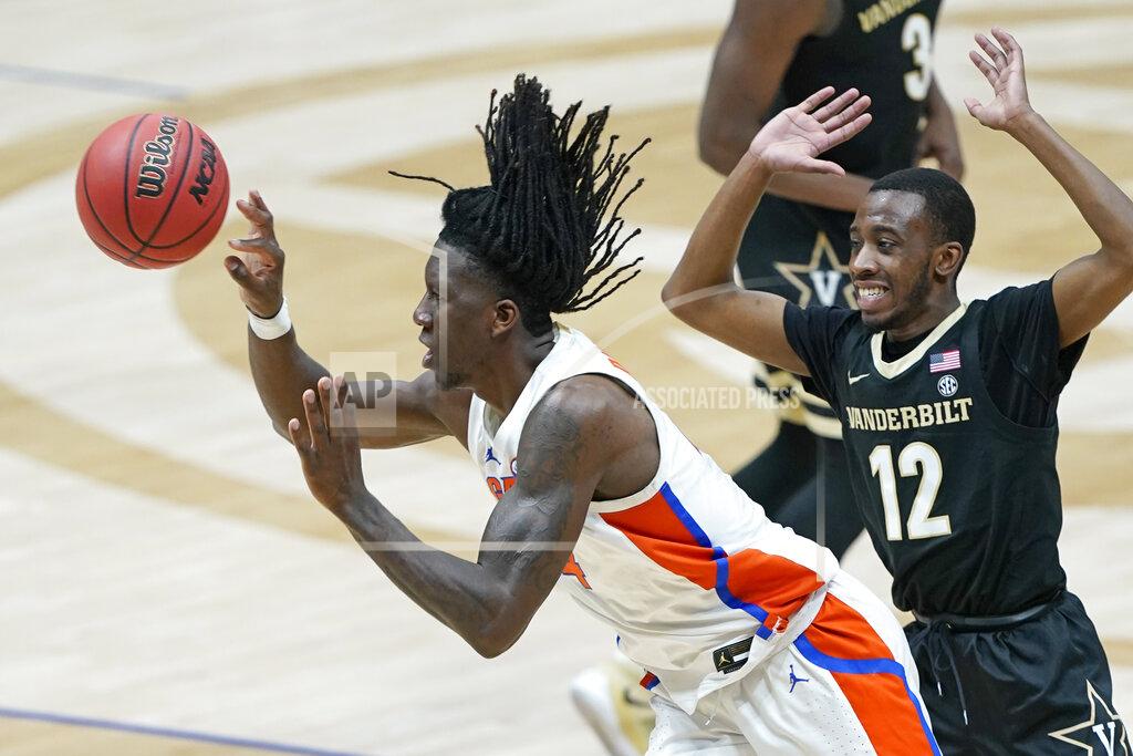 Mark Humphrey Florida's Anthony Duruji, left, passes the ball as he is defended by Vanderbilt's Trey Thomas (12) in the second half of an NCAA college basketball game in the Southeastern Conference Tournament Thursday, March 11, 2021, in Nashville, Tenn. (AP Photo/Mark Humphrey)