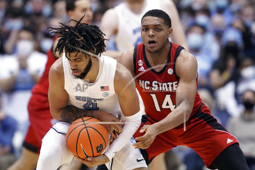 Gerry Broome North Carolina guard R.J. Davis (4) controls the ball against North Carolina State guard Casey Morsell (14) during the second half of an NCAA college basketball game in Chapel Hill, N.C., Saturday, Jan. 29, 2022. (AP Photo/Gerry Broome)