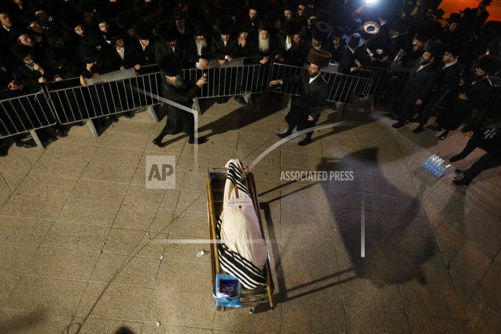 Ariel Schalit Ultra-Orthodox mourners gather around the body of Menachem Knoblowitz, 21, from the United States, who died during Lag BaOmer celebrations at Mt. Meron in northern Israel, at his funeral in Jerusalem on Saturday, May 1 2021. A stampede at a religious festival attended by tens of thousands of ultra-Orthodox Jews in northern Israel killed dozens of people and injured about 150 early Friday, medical officials said. It was one of the country's deadliest civilian disasters. (AP Photo/Ariel Schalit)