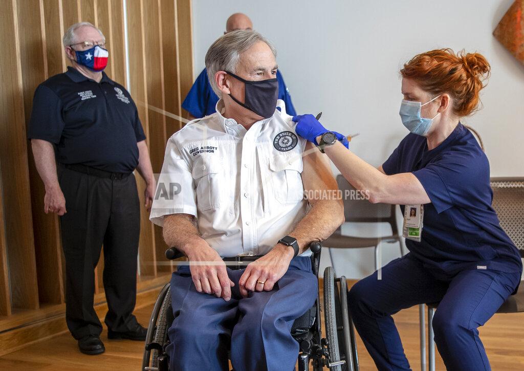 Registered nurse April Burgeons administers a dose of a Pfizer-BioNtech COVID-19 vaccine to Texas Gov. Greg Abbott at the Ascension Seton Medical Center on Tuesday, Dec. 22, 2020. Commissioner Dr. John William Hellerstedt of the Texas Department of State Health Services far left and Registered nurse Toby Hatton looks on. (Ricardo B. Brazziell /Austin American-Statesman via AP)
