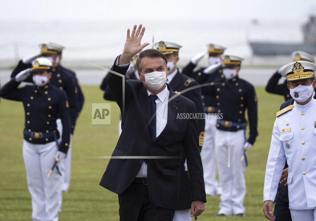 Silvia Izquierdo Brazilian President Jair Bolsonaro greets those gathered for a graduation ceremony at the Naval Academy, in Rio de Janeiro, Brazil, Saturday, June 19, 2021, amid the COVID-19 pandemic. People gathered across the country Saturday, to protest Bolsonaro's handling of the pandemic and economic policies protesters say harm the interests of the poor and working class. (AP Photo/Silvia Izquierdo)
