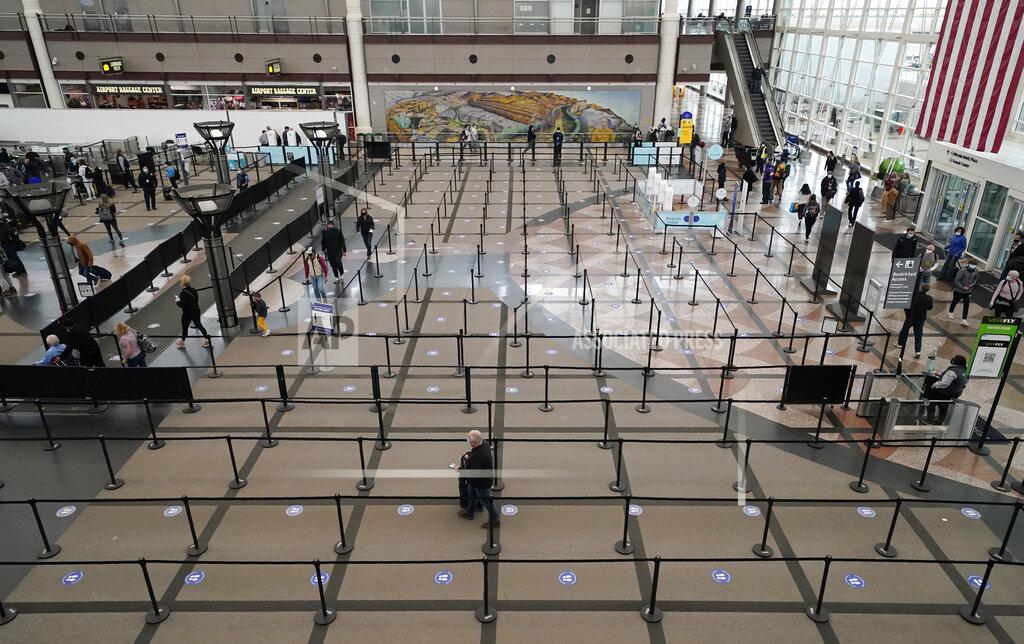 David Zalubowski FILE - Travelers head through the south security checkpoint check in the terminal of Denver International Airport, Thursday, Dec. 10, 2020, in Denver. The coronavirus pandemic created winners and losers in the business world. Wall Street recovered after March, even though Main Street is still struggling. As few people traveled, the airline industry needed billions of dollars in aid from the government and is still threatening to lay off workers.(AP Photo/David Zalubowski, File)