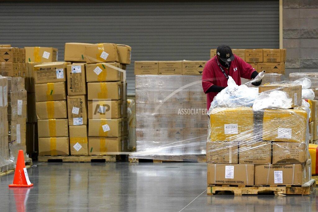 Ross D. Franklin A worker helps prep one of dozens of pallets with over one million pieces of PPE to help Phoenix schools reopen for the 2020-2021 school year fill a Phoenix Convention Center hall as the City of Phoenix begins to ship the pallets out to schools Tuesday, Sept. 8, 2020, in Phoenix. (AP Photo/Ross D. Franklin)