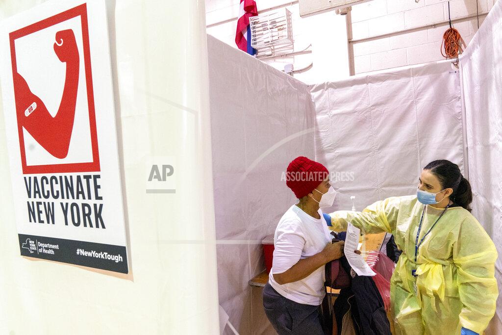 Mary Altaffer Registered Nurse Rita Alba, right, directs Alba Carrasco to the recovery area after giving her the first dose of the coronavirus vaccine at a pop-up COVID-19 vaccination site at the Bronx River Addition NYCHA complex, Sunday, Jan. 31, 2021, in the Bronx borough of New York. From elderly Cuban Americans in Florida to farmworkers in California, Latinos face daunting barriers like fear, language and a lack of education and access as the COVID-19 vaccines roll out, creating risks for public health as the virus mutates and spreads. (AP Photo/Mary Altaffer)