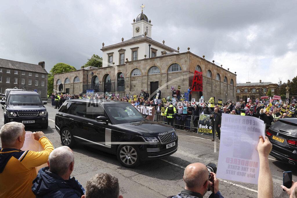 Liam Mcburney People demonstrate outside Hillsborough Castle as the motorcade of British Prime Minister Boris Johnson passes by during his visit, in Hillsborough, Northern Ireland, Monday, May 16, 2022. Johnson on Monday renewed British threats to break a Brexit agreement with the European Union, blaming it for a political crisis that's blocking the formation of a new government in Northern Ireland. (Liam McBurney/PA Wire/PA via AP)