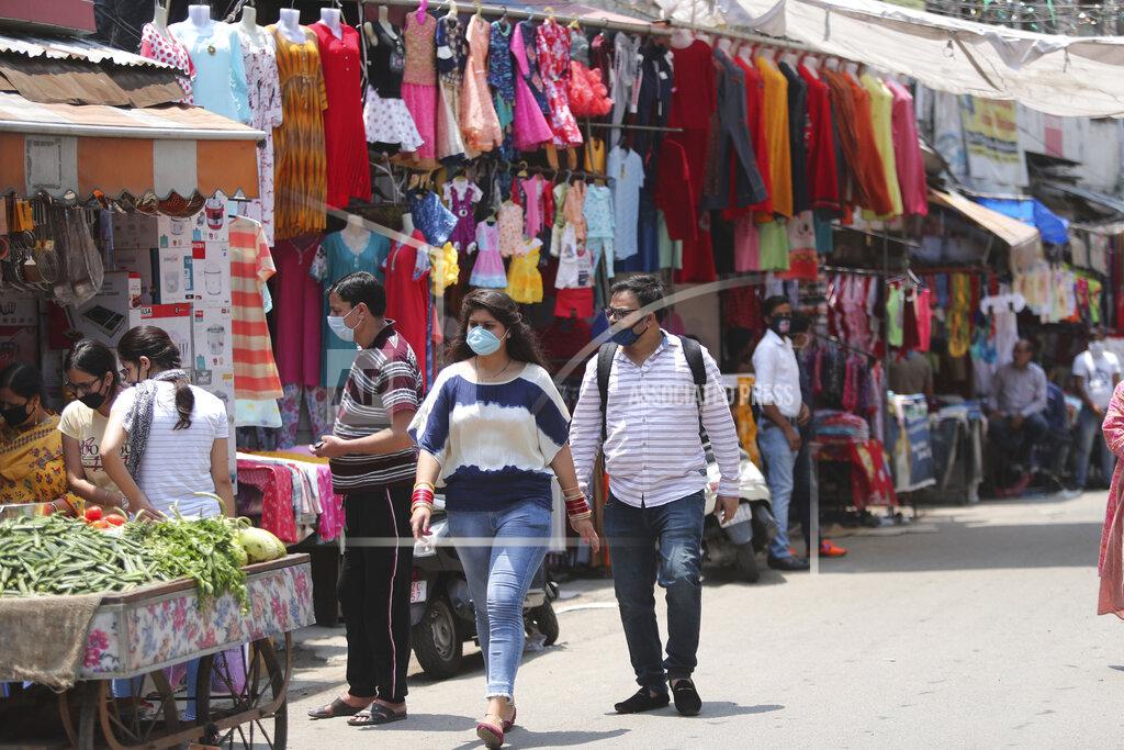Channi Anand Indian commuters wear masks and walk at a market in Jammu, India, Sunday, June 7, 2020. India whose coronavirus caseload is fifth highest in the world has partially restored trains and domestic flights and allowed reopening of shops and manufacturing. (AP Photo/Channi Anand)