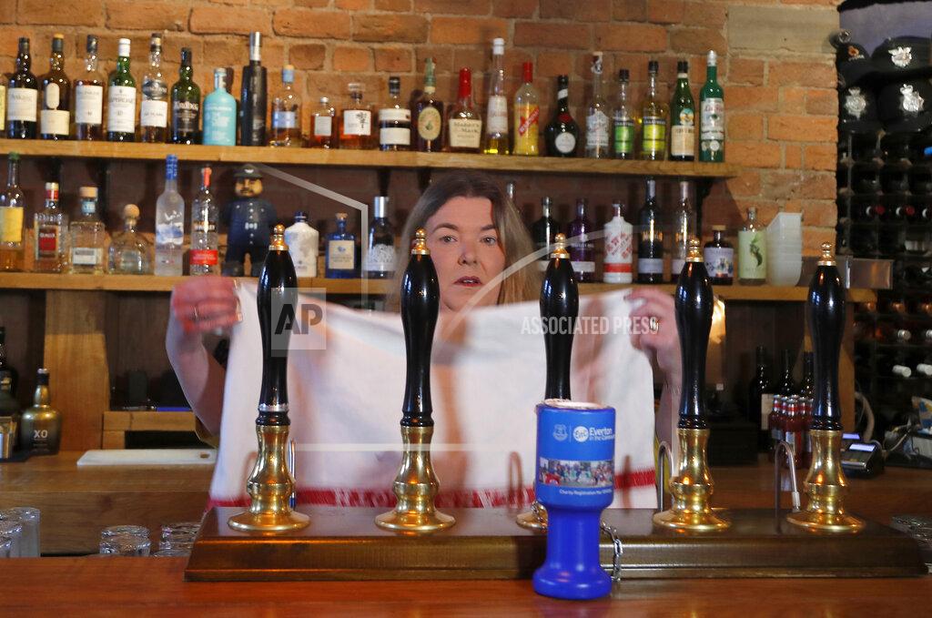 Frank Augstein Fiona Hornsby, the owner of the Bridewell pub puts a towel over the beer taps in Liverpool, England, Wednesday, Oct. 14, 2020. As the first area in England slapped with strict new restrictions to curb the resurgent coronavirus that have shuttered pubs and imperiled thousands of jobs, Liverpool again feels it's being punished by policies made in Britain's capital, 180 miles (290 kilometers) to the south. (AP Photo/Frank Augstein)