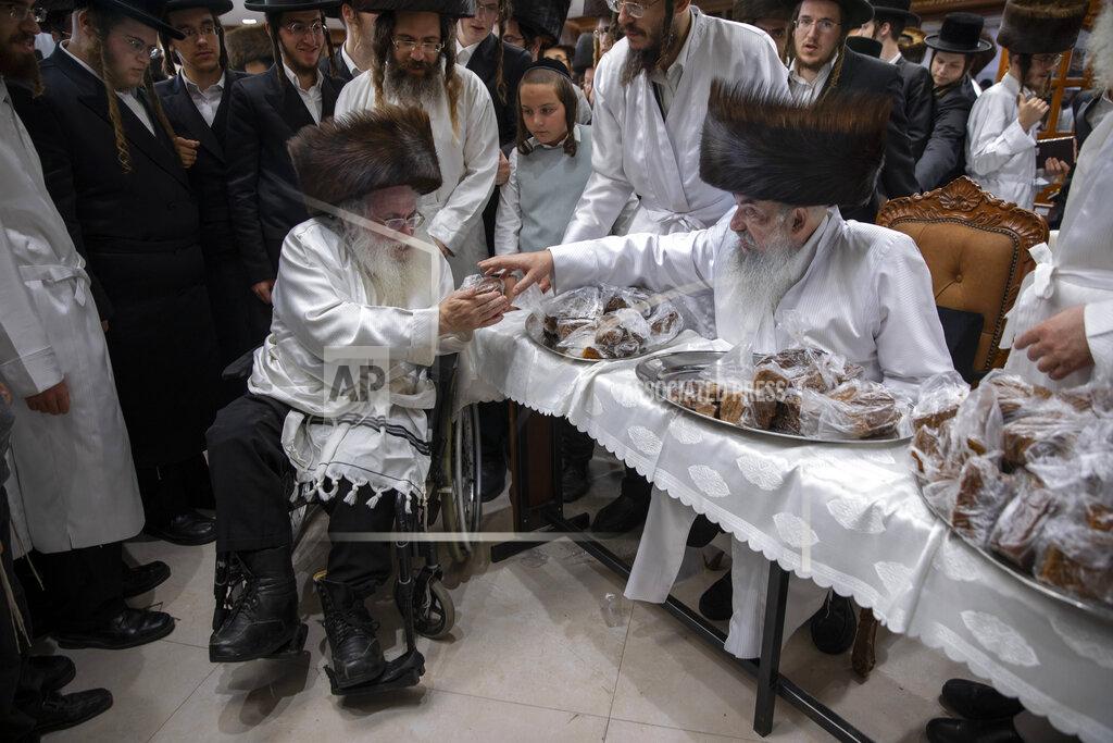 Oded Balilty Rabbi Aharon Biderman gives cakes to his followers just before the start of the Jewish holiday of Yom Kippur, in the city of Beit Shemesh, Israel, Wednesday, Sept. 15, 2021. Yom Kippur is Judaism's day of atonement, when devout Jews ask God to forgive them for their transgressions and refrain from eating and drinking, attending intense prayer services in synagogues. (AP Photo/Oded Balilty)