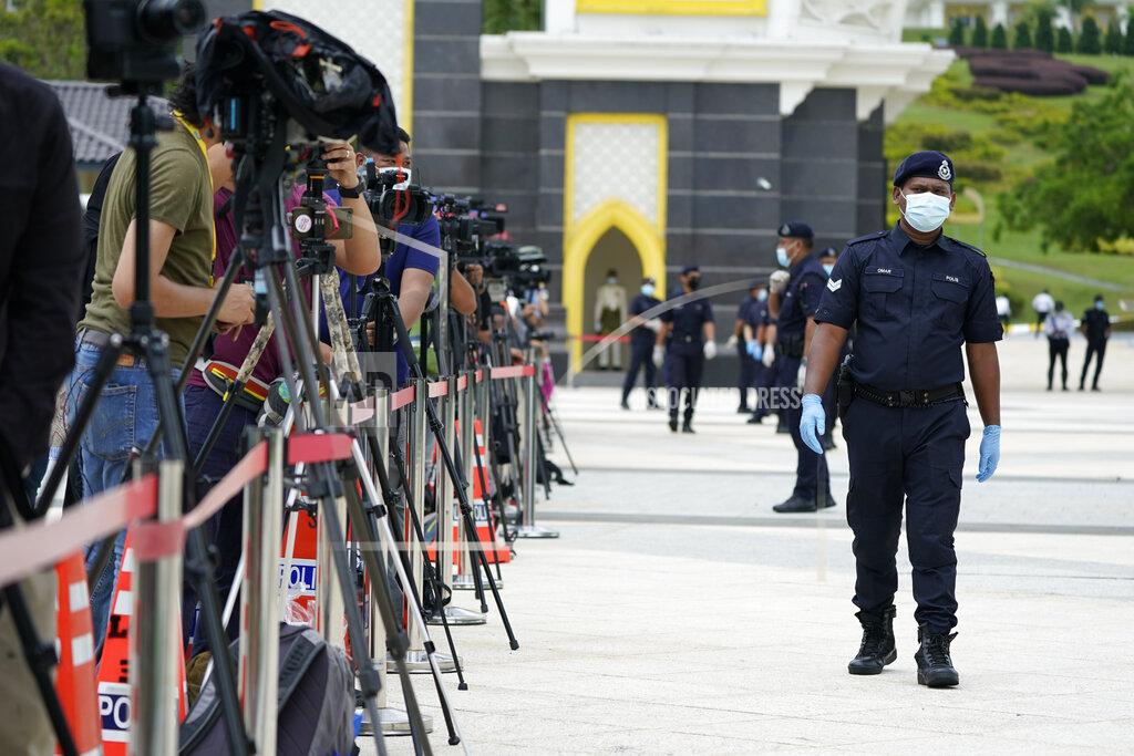 Vincent Thian Police wearing a face mask to help curb the spread of the coronavirus guard media outside National Palace in Kuala Lumpur, Malaysia, Sunday, Oct. 25, 2020. Malay rulers hold a special meeting on Sunday to discuss the government's plan to declare an emergency to tackle the worsening COVID-19 situation. (AP Photo/Vincent Thian)