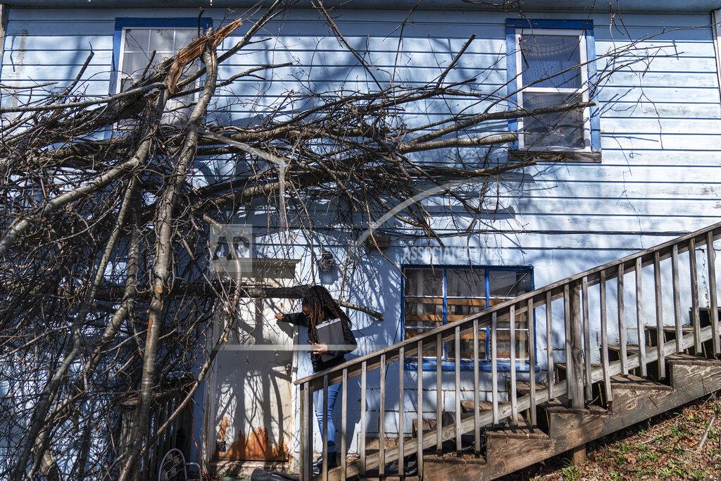 David Goldman Larrecsa Cox, who leads the Quick Response Team which visits everyone who overdoses to offer help, knocks on the door of a home that suffered tree damage from a recent storm as she checks on a client in Huntington, W.Va., Friday, March 19, 2021. The pandemic proved the perfect storm for those already in the shadows: it drove them further into isolation, economic fragility and fear while at the same time upending the treatment and support systems that might save them. (AP Photo/David Goldman)