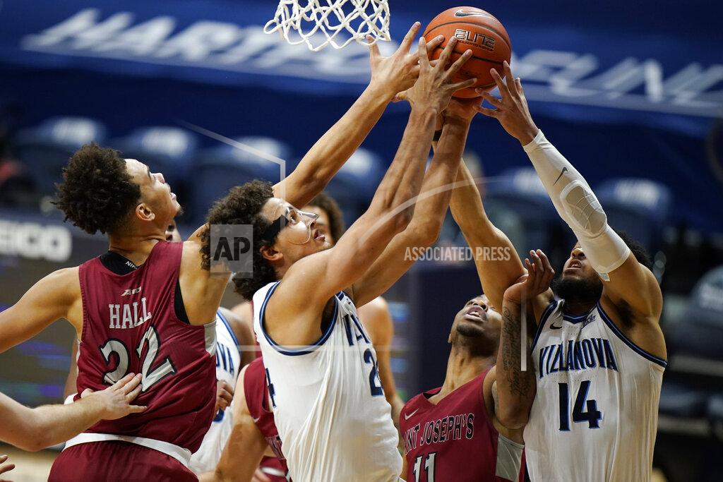 Matt Slocum Villanova's Caleb Daniels (14) and Jeremiah Robinson-Earl (24) leap for a rebound against Saint Joseph's Rahmir Moore (11) and Jordan Hall (22) during the first half of an NCAA college basketball game, Saturday, Dec. 19, 2020, in Villanova, Pa. (AP Photo/Matt Slocum)