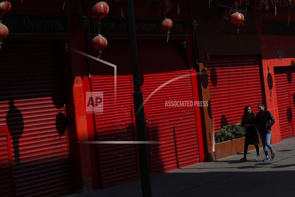 Rebecca Blackwell Pedestrians walk past closed shops in Chinatown, which like the rest of the central commercial district has had to close non-essential businesses in accordance with a government shutdown to fight the spread of the new coronavirus, in Mexico City, Saturday, April 18, 2020. (AP Photo/Rebecca Blackwell)