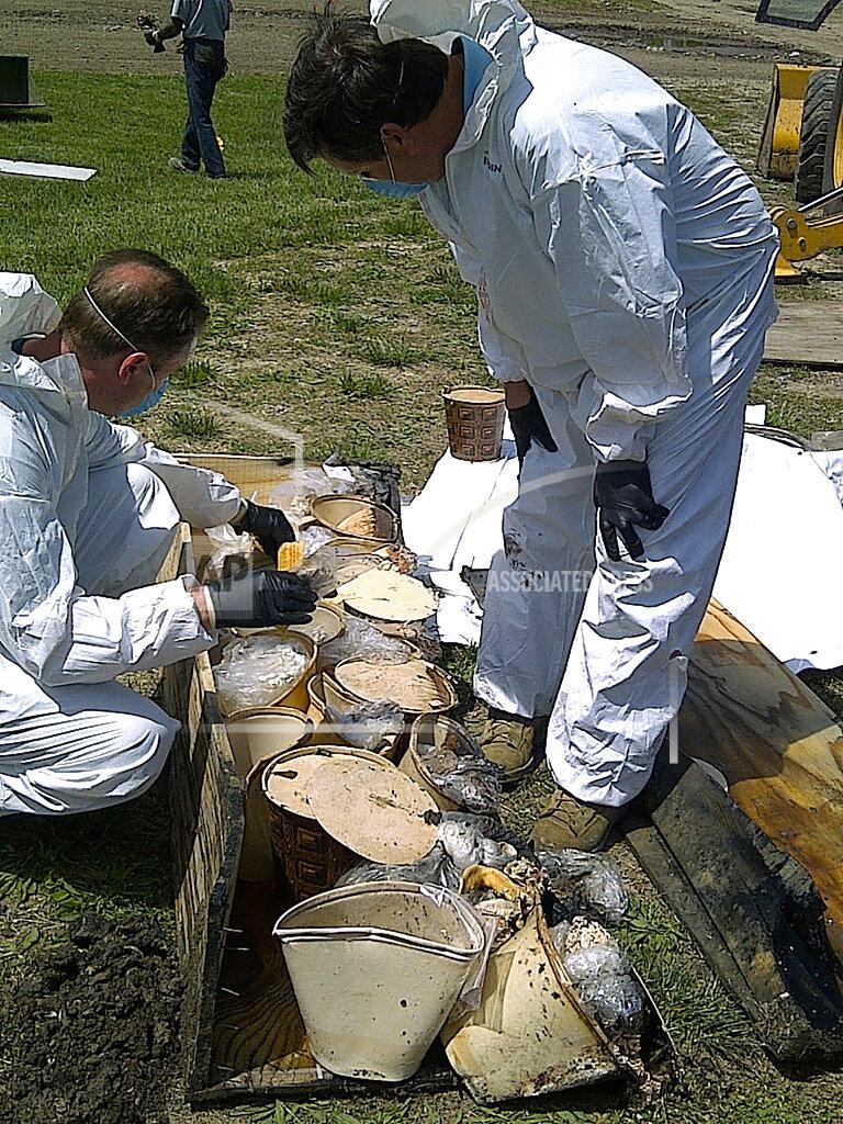 Uncredited FILE - In this undated file photo provided by the Cook County Sheriff's Office, authorities look through buckets containing jaw bones and teeth of victims of serial killer John Wayne Gacy, who was convicted of killing 33 young men and boys in the Chicago area in the 1970s. Authorities announced Monday, Oct. 25, 2021, that they have identified the remains of one more of Gacy's victims. (AP Photo/Cook County Sheriff's Office, File)