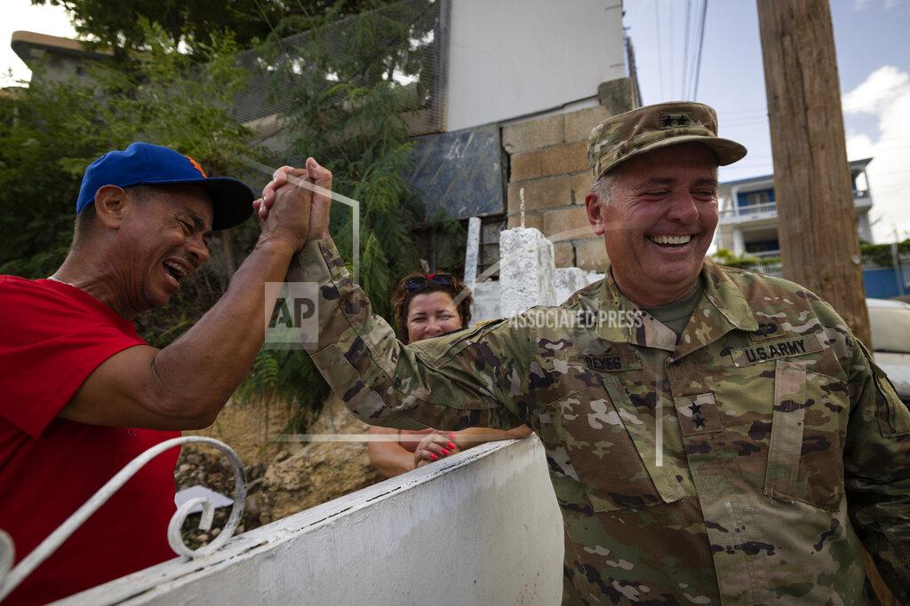 Alejandro Granadillo A National Guardsman greets a neighbor after delivering water to the residents of Punta Diamante in Ponce, Puerto Rico, Wednesday, September 21, 2022. (AP Photo/Alejandro Granadillo)