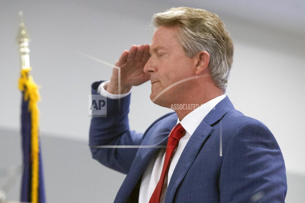 Uncredited Congressman Roger Marshall salutes the flag during the Pledge of Allegiance at a GOP watch party at the Cyrus Hotel, Tuesday, Nov. 3, 2020 in downtown Topeka, Kan. Marshall is running against Barbara Bollier for the Kansas seat in the U.S. Senate. (Evert Nelson/The Topeka Capital-Journal via AP)