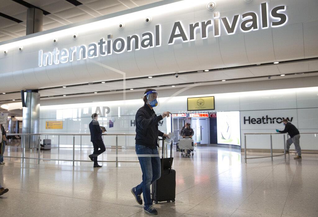 Matt Dunham A passenger wearing a face shield and face mask arrives on the first day of new rules that people arriving in Britain from overseas will have to quarantine themselves for 14 days to help stop the spread of coronavirus, at Heathrow Airport in London, Monday, June 8, 2020. The British government has said that anyone caught not complying with the quarantine will face a fine. (AP Photo/Matt Dunham)