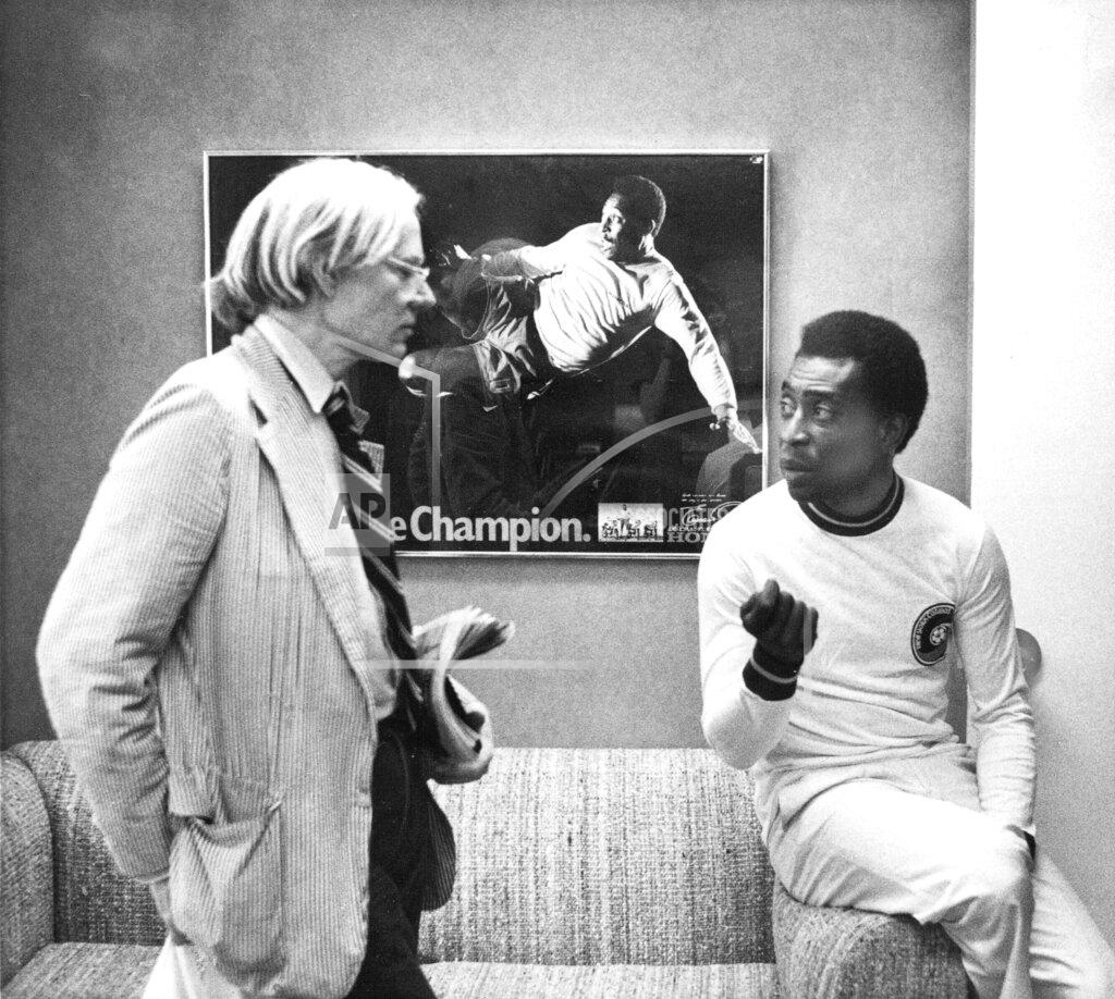 FILE - In this July 26, 1977 file photo, surrealist artist Andy Warhol speaks with Brazil's soccer player Pele about a portrait after Warhol was commissioned to make a series of portraits of athletic stars in New York. On Oct. 23, 2020, the three-time World Cup winner Pelé turns 80 without a proper celebration amid the COVID-19 pandemic as he quarantines in his mansion in the beachfront city of Guarujá, where he has lived since the start of the pandemic. (AP Photo/Claudia Larson, File)