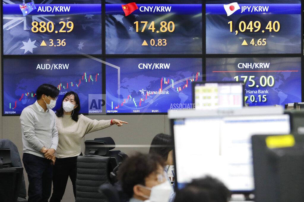 Ahn Young-Joon Currency traders pass by screens showing foreign exchange rates at the foreign exchange dealing room of the KEB Hana Bank headquarters in Seoul, South Korea, Thursday, March 11, 2021. Stocks climbed in Asia on Thursday after a key measure of inflation in the U.S. came in lower than expected, easing worries that price pressures could push interest rates higher. (AP Photo/Ahn Young-joon)