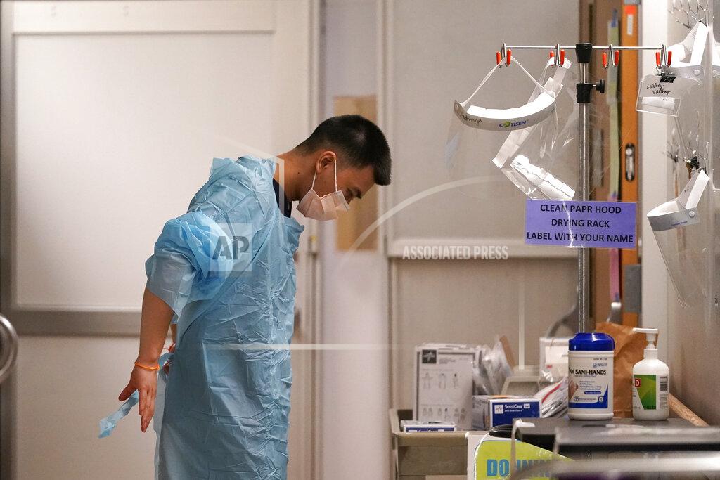 Elaine Thompson Respiratory therapist Bailey Synhavong begins to put on protective equipment, which will include a face shield, gloves, gown, head cover and mask, before going into a patient's room in the COVID intensive care unit at UW Medical Center-Montlake, Tuesday, Jan. 26, 2021, in Seattle. King County, where the hospital is located, has been on a downward trend of COVID-19 cases after two-and-a-half straight months of increases. But the current lull could be, and some experts believe will be, upended as more contagious variants of the virus spread throughout United States. (AP Photo/Elaine Thompson)