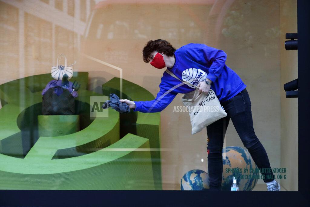 Kirsty Wigglesworth A worker cleans a Selfridges department store shop window on Oxford Street in London, Monday, April 12, 2021. Millions of people in England will get their first chance in months for haircuts, casual shopping and restaurant meals on Monday, as the government takes the next step on its lockdown-lifting road map. (AP Photo/Kirsty Wigglesworth)