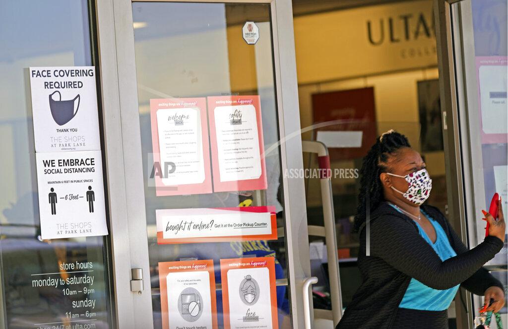 Lm Otero A customer exits a store with a mask required sign displayed, Tuesday, March 2, 2021, in Dallas. (AP Photo/LM Otero)