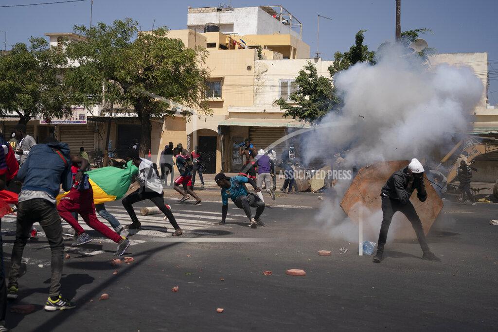 Leo Correa Demonstrators run after rioT police fired a stone grenade during protests against the arrest of opposition leader and former presidential candidate Ousmane Sonko, Senegal, Monday, March 8, 2021. Senegalese authorities have freed opposition leader Ousmane Sonko while he awaits trial on charges of rape and making death threats. The case already has sparked deadly protests threatening to erode Senegal's reputation as one of West Africa’s most stable democracies. (AP Photo/Leo Correa)