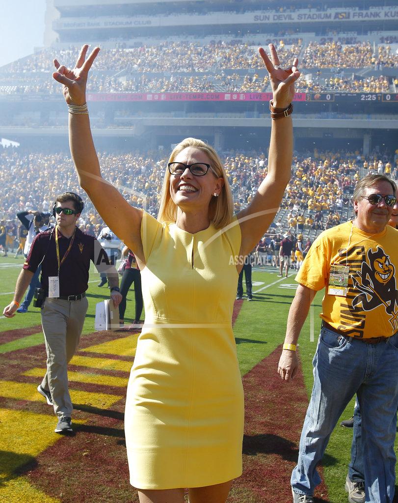 Rick Scuteri Democratic U.S. Senate candidate Kyrsten Sinema gestures before performing the coin toss before an NCAA college football game between Arizona State and Utah, Saturday, Nov 3, 2018, in Tempe, Ariz. (AP Photo/Rick Scuteri)