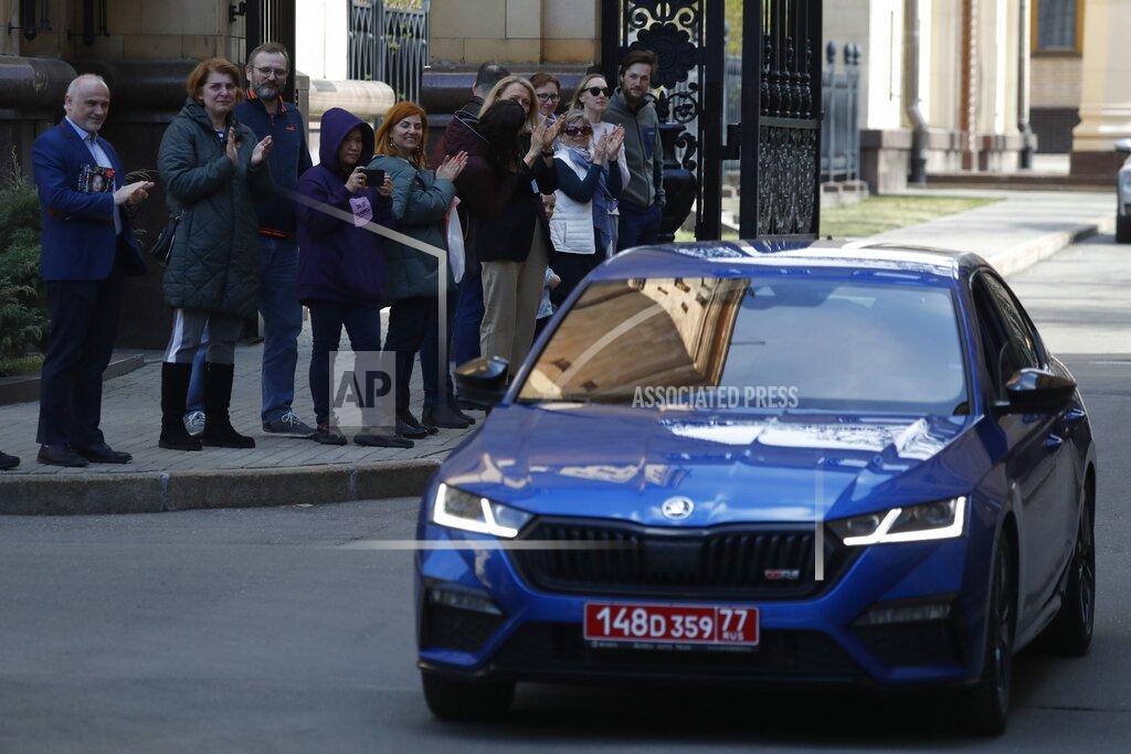 Pavel Golovkin Embassy staff leave the Czech Republic Embassy by car as others applaud them, in Moscow, Russia, Monday, April 19, 2021. Russia has ordered 20 Czech diplomats to leave the country within a day in response to Prague's expulsion of 18 Russian diplomats. The Czech government has alleged the Russian Embassy staffers were spies for a military intelligence agency that was involved in a fatal ammunition depot explosion in 2014. (AP Photo/Pavel Golovkin)