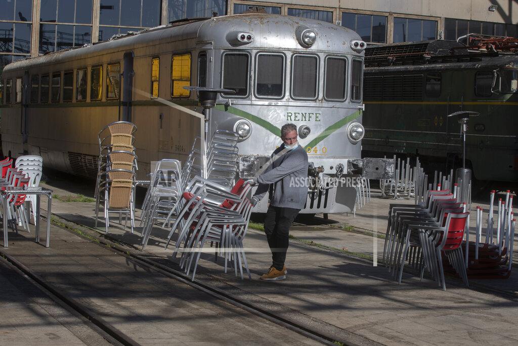 Paul White A bar worker sets out tables and chairs in a terrace bar outside an old train station which is currently a railway museum, in Madrid, Spain, Sunday, Feb. 14, 2021. Several central Spanish regions including Madrid have announced some easing of curfews and restrictions on bar and restaurants despite warnings to keep a high alert despite a slowing curve of the Coronavirus contagion. (AP Photo/Paul White)