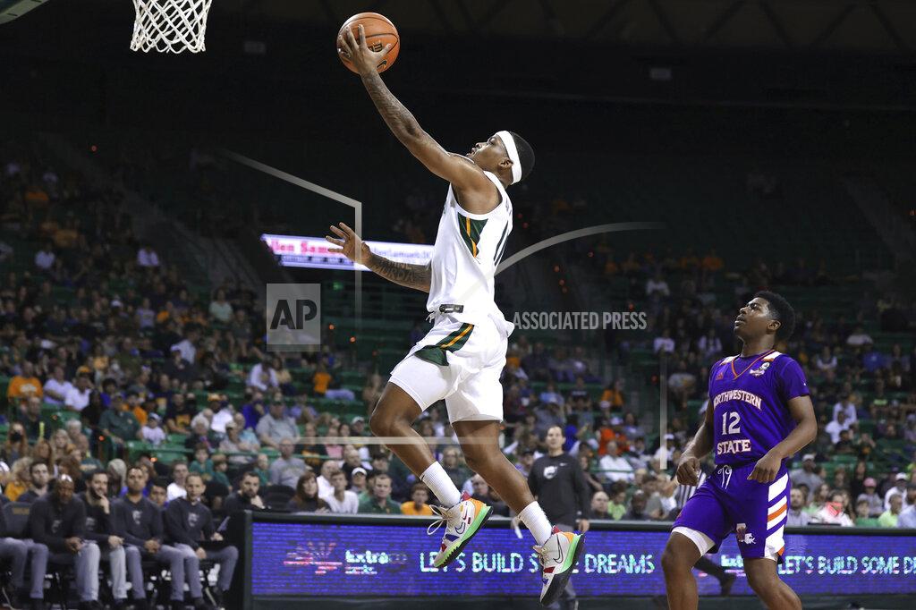 Rod Aydelotte Baylor guard James Akinjo scores past Northwestern State guard Carvell Teasett, right, during the second half of an NCAA college basketball game Tuesday, Dec. 28, 2021, in Waco, Texas. (AP Photo/Rod Aydelotte)